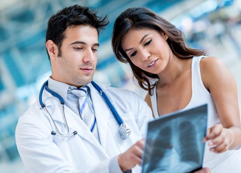 Doctor checking x-ray of a female patient at the hospital